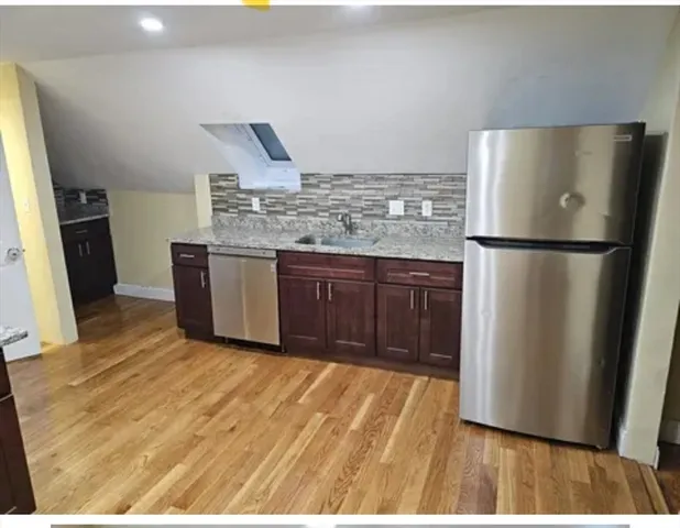 a kitchen with stainless steel appliances granite countertop a refrigerator a sink and a stove