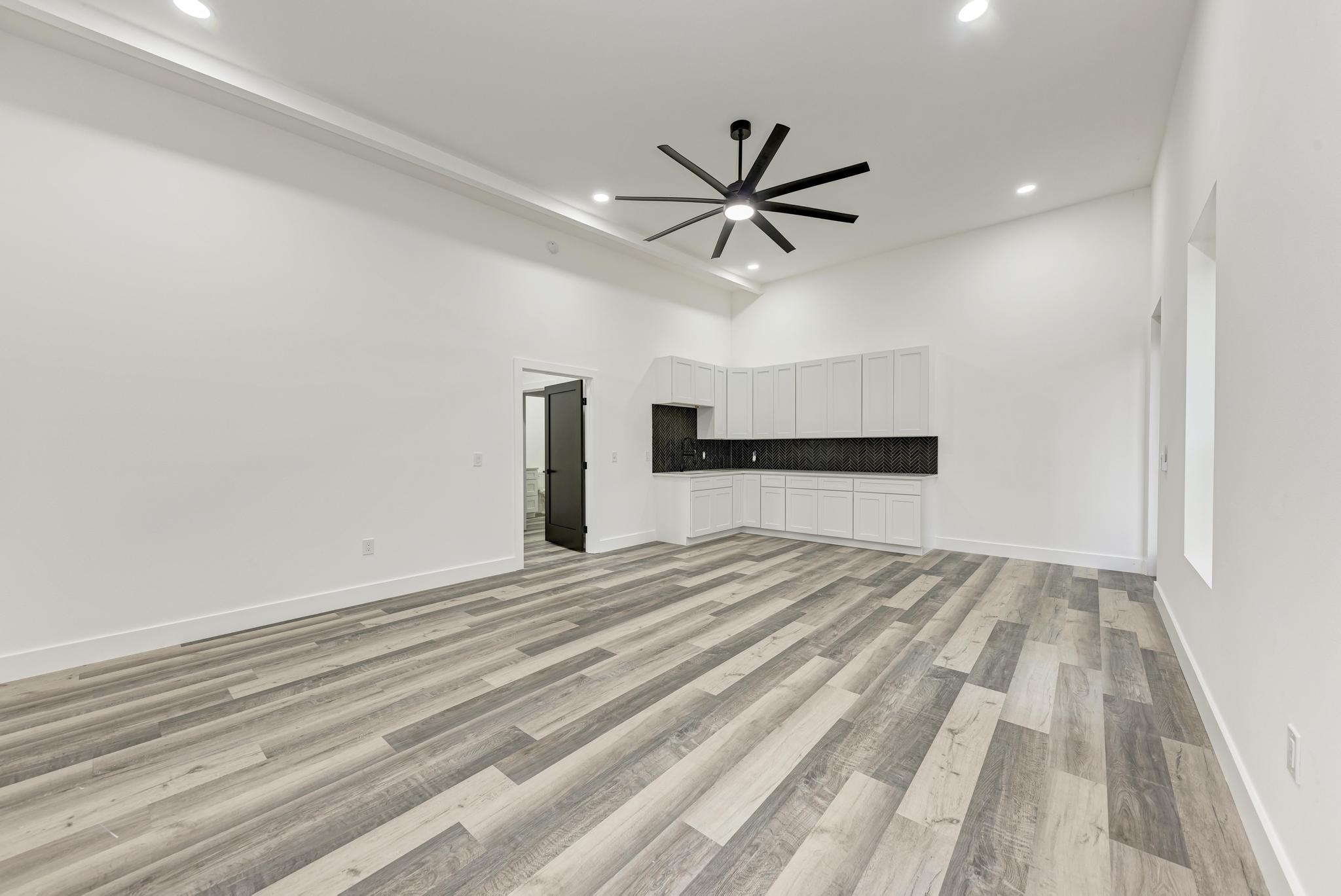 4190 West Fm 243 Bertram, TX 78605 - Photo 33 of 42 Unfurnished living room featuring ceiling fan, light wood finished floors, recessed lighting, and a high ceiling