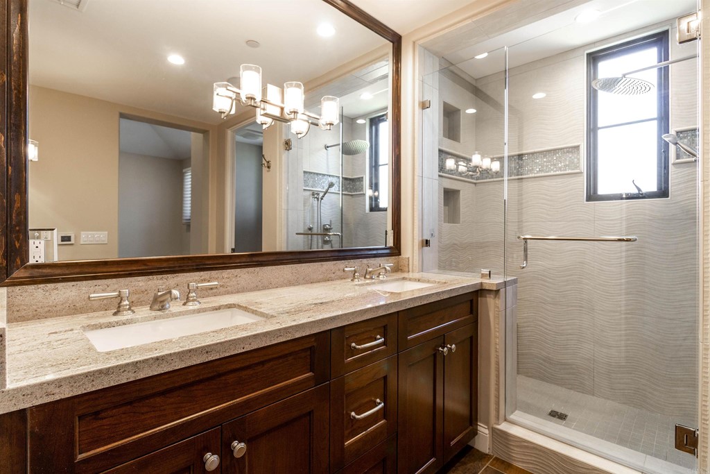 728 Silver Street La Jolla, CA 92037 - Photo 27 of 44 a bathroom with a granite countertop sink a large mirror and a shower