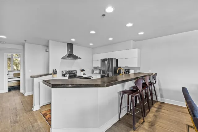 a kitchen with kitchen island stainless steel appliances a sink and a refrigerator