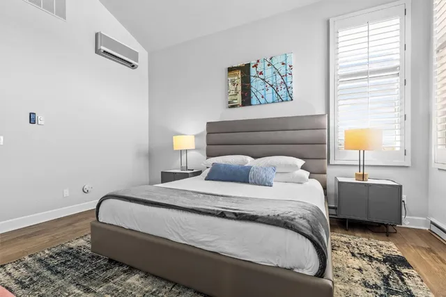 a bedroom with a bed lamp and a window