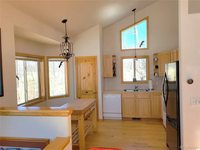 a view of a kitchen with a sink a refrigerator and a view of living room