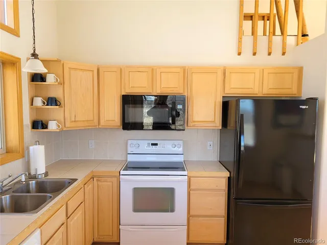 a kitchen with a refrigerator sink and cabinets