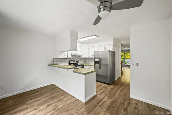 a kitchen with stainless steel appliances granite countertop a refrigerator and a stove top oven