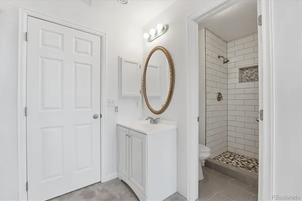 a bathroom with a granite countertop shower and a mirror
