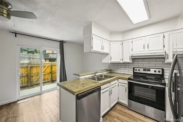 a kitchen with a stove sink and cabinets