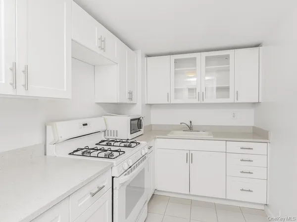 a kitchen with cabinets appliances a sink and a counter top