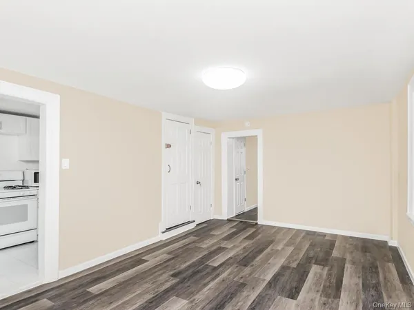 a view of a room with wooden floor and white walls