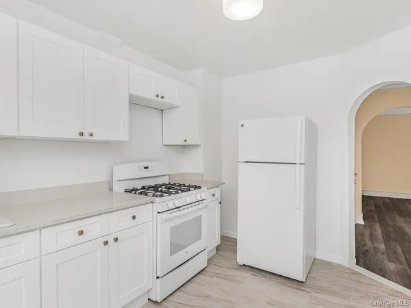 a kitchen with white cabinets and white appliances