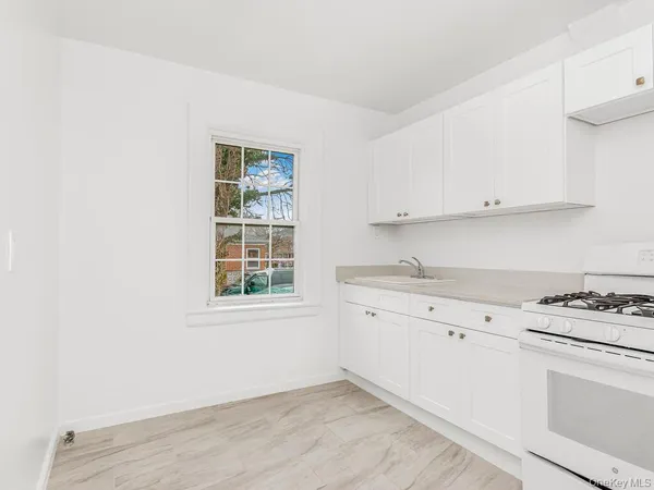 a kitchen with granite countertop white cabinets and white appliances