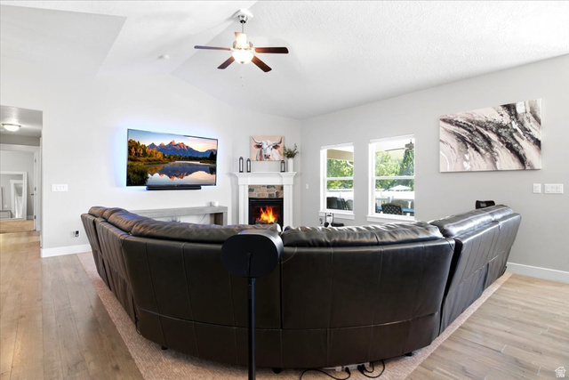 2973 West Red Sand Rd Haven Ogden, UT 84401 - Photo 14 of 30 Living area featuring a fireplace with stone surround, a white mantle, and a wall-mounted television