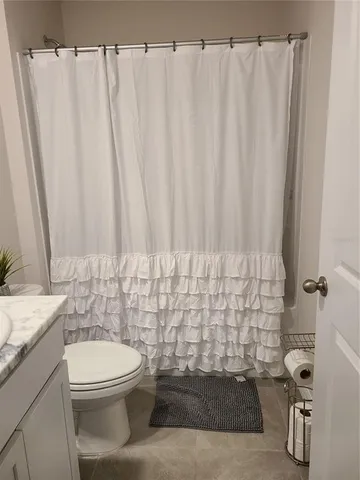 a bathroom with a toilet a sink and curtain