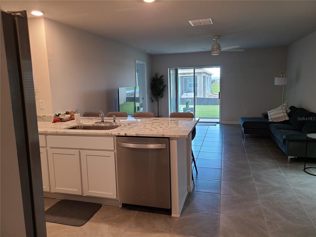 10209 Kalamazoo Place Parrish, FL 34219 - Photo 3 of 25 a kitchen with kitchen island granite countertop a sink cabinets and wooden floor