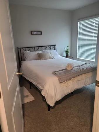 a bed sitting in a bedroom next to a window