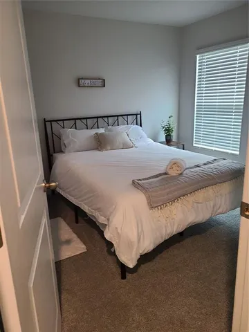 a bed sitting in a bedroom next to a window