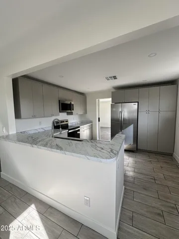 a kitchen with granite countertop a sink and a refrigerator