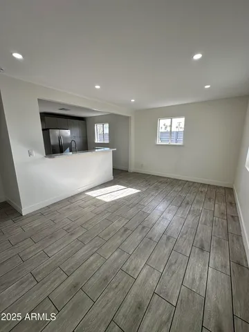 a view of a livingroom with wooden floor and staircase