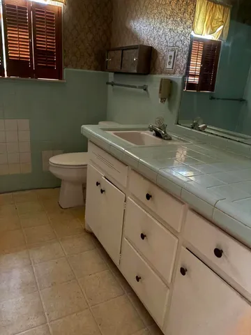 a bathroom with a toilet sink and mirror