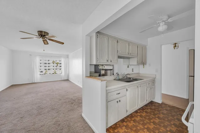a kitchen with granite countertop a sink a stove and white cabinets