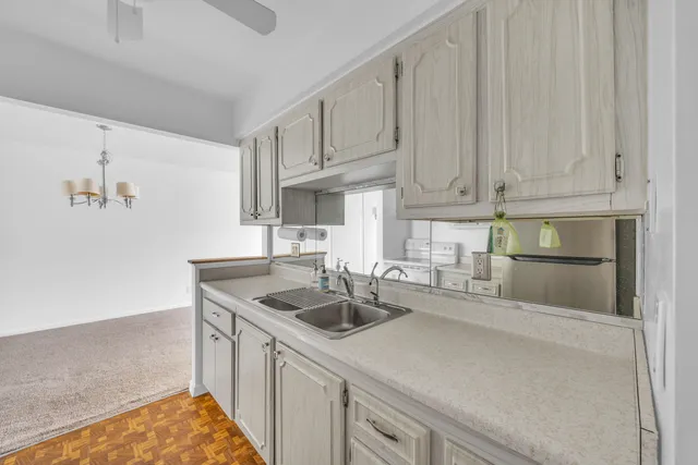 an empty room with windows and chandelier fan