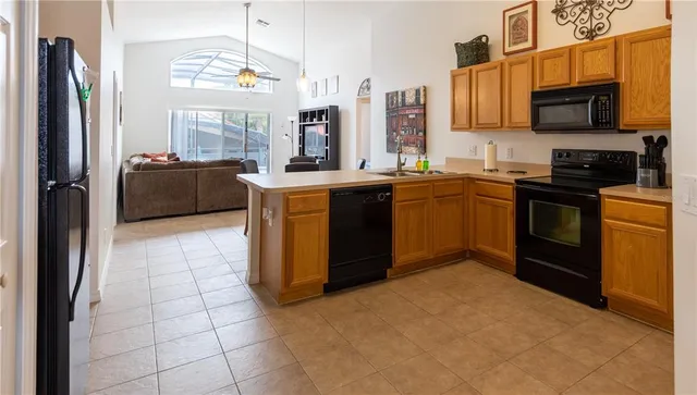 a kitchen with stainless steel appliances granite countertop a stove top oven a sink dishwasher a refrigerator and cabinets