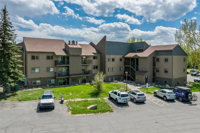 a street view with couple of cars parked in front of house
