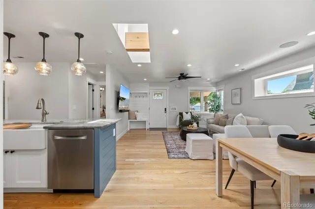 a living room with furniture a rug and kitchen view
