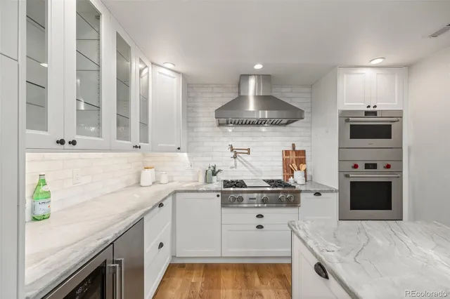 a kitchen with kitchen island granite countertop stainless steel appliances a sink stove and cabinets