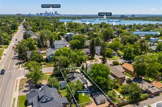 an aerial view of residential houses with outdoor space and trees