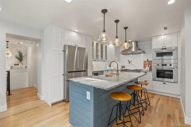 a kitchen with stainless steel appliances granite countertop a sink a stove and a refrigerator