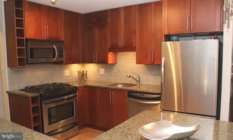 a kitchen with stainless steel appliances granite countertop a refrigerator stove top oven a sink and dishwasher