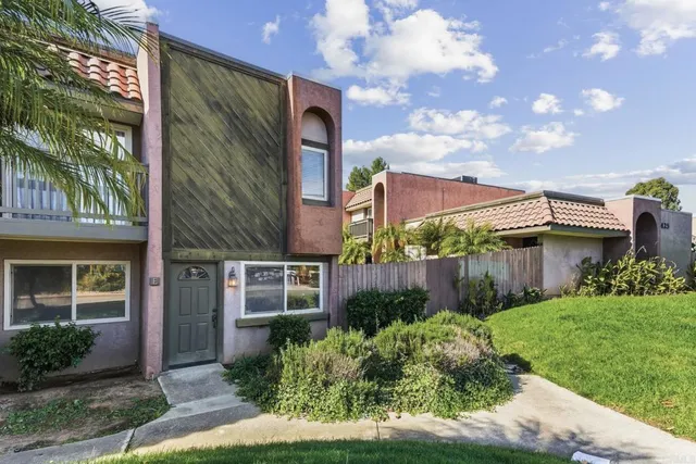 a view of a house with brick walls and a yard with plants