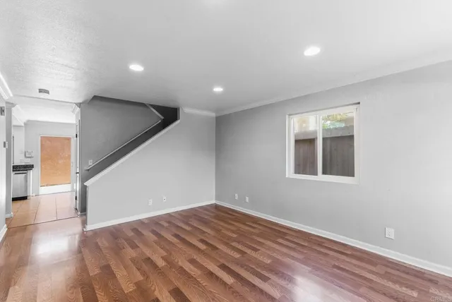 a view of empty room with wooden floor