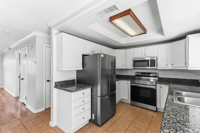 a kitchen with stainless steel appliances granite countertop a refrigerator and a stove