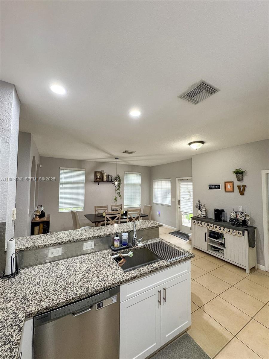 27841 Southwest 140th Avenue Homestead, FL 33032 - Photo 12 of 28 a kitchen with stainless steel appliances granite countertop a sink stove and cabinets