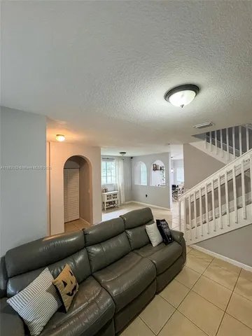 a living room with furniture and stairs