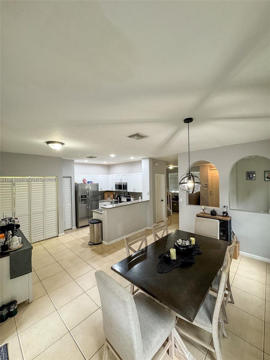 27841 Southwest 140th Avenue Homestead, FL 33032 - Photo 10 of 28 a kitchen with a sink a counter and chairs