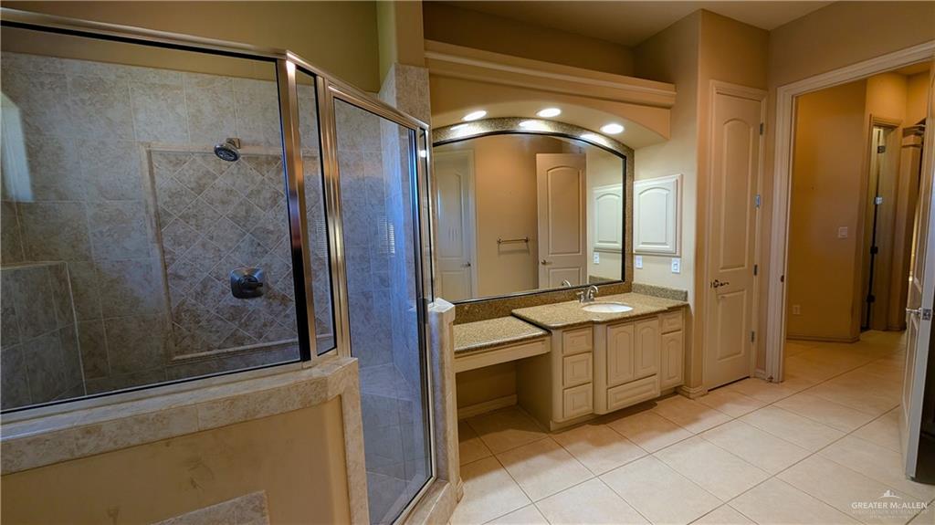 5805 Acacia Harlingen, TX 78552 - Photo 12 of 23 Bathroom with light tile patterned floors, vanity, and a shower stall
