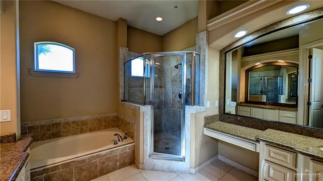 a bathroom with a tub a sink and a large mirror