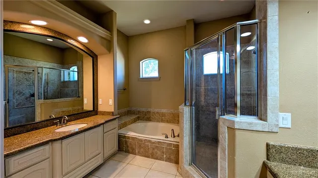 a bathroom with a tub and a double vanity sink mirror