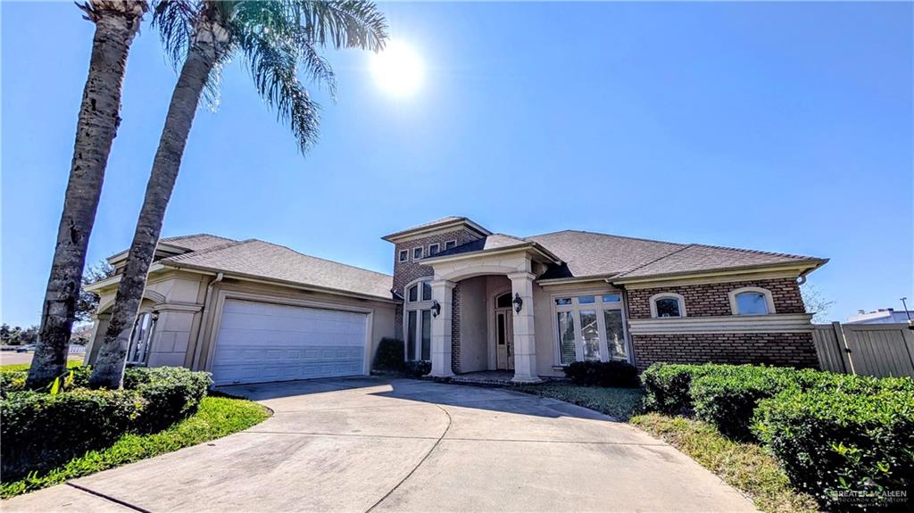 5805 Acacia Harlingen, TX 78552 - Photo 4 of 23 View of front facade featuring concrete driveway, brick siding, an attached garage, and roof with shingles