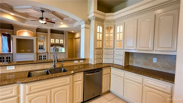a kitchen with granite countertop a sink and white cabinets