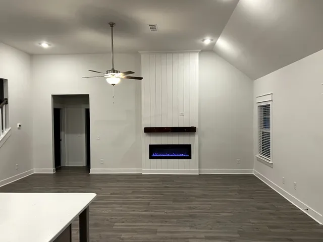 an empty room with closet and a ceiling fan