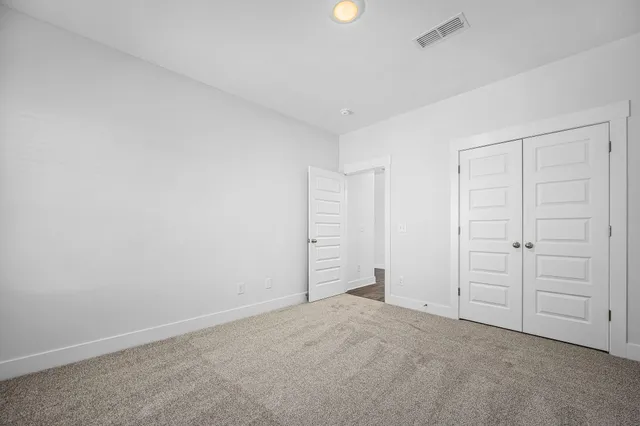 an empty room with ceiling fan and window