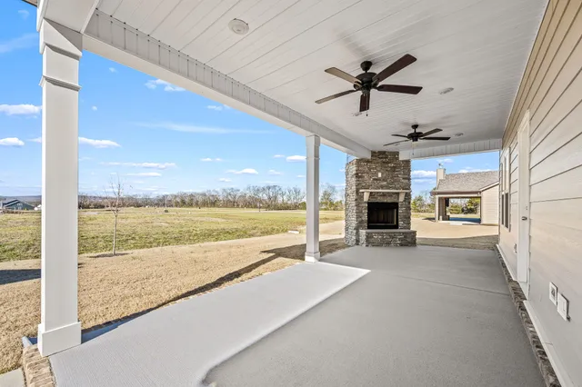 a view of an empty room with a fireplace and a chandelier