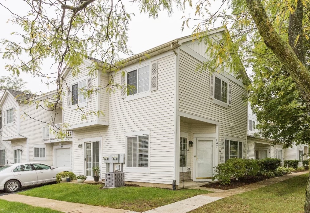 147 Heather Glen Drive, Unit 147 Aurora, IL 60504 - Photo 1 of 14 a view of a white house next to a yard with a fountain and a large tree