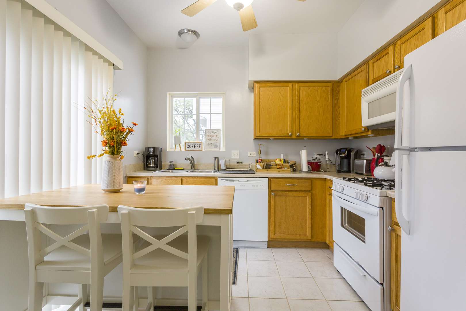 147 Heather Glen Drive, Unit 147 Aurora, IL 60504 - Photo 9 of 14 a kitchen with a stove a sink and white cabinets