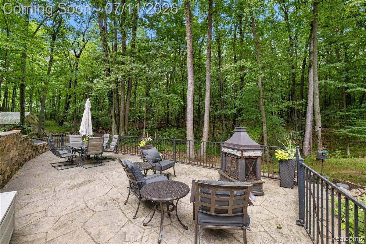 4219 Gardner Road Metamora, MI 48455 - Photo 65 of 87 Expansive stamped concrete patio featuring a decorative stone retaining wall and black metal railings