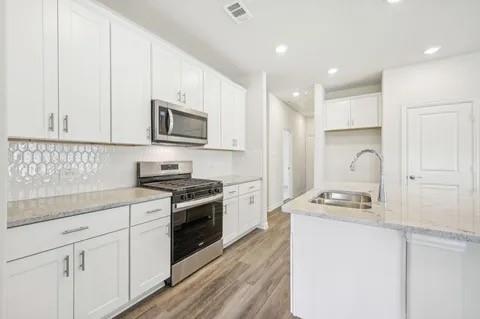519 Ridgedale Drive McKinney, TX 75071 - Photo 2 of 26 a kitchen with granite countertop white cabinets and stainless steel appliances