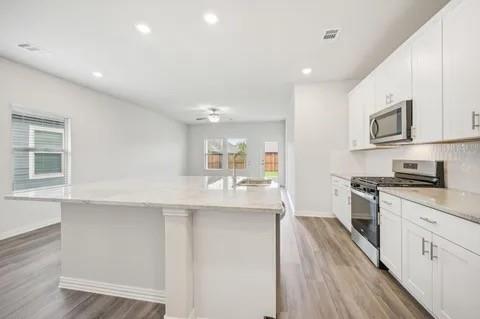519 Ridgedale Drive McKinney, TX 75071 - Photo 4 of 26 a large kitchen with stainless steel appliances granite countertop a lot of counter space and wooden floor
